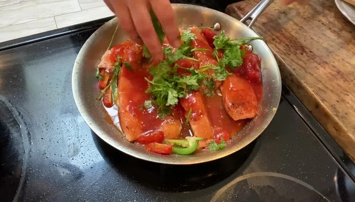 Chop or rip cilantro leaves and place them over the fish.