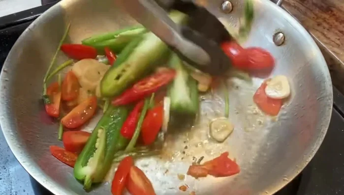 Arrange jalapenos and tomatoes in the skillet.