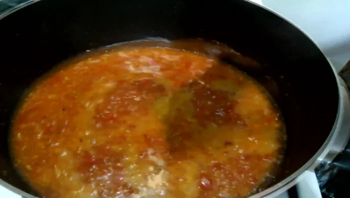 Add enough water to loosen the mixture. Once simmering, add tilapia pieces.