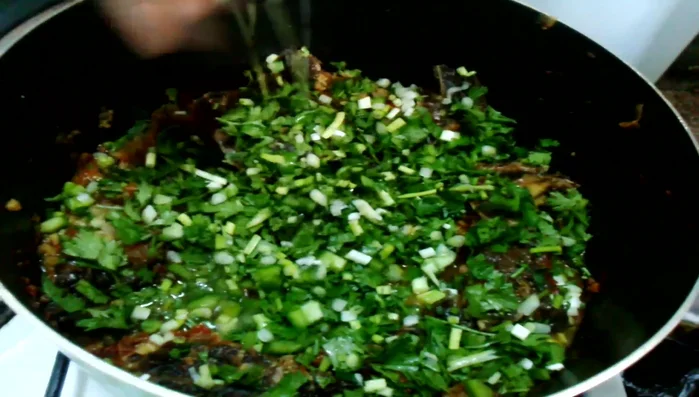 Add da leaves and spring onions. Add a little water to steam them. Cover and simmer for 1-2 minutes.