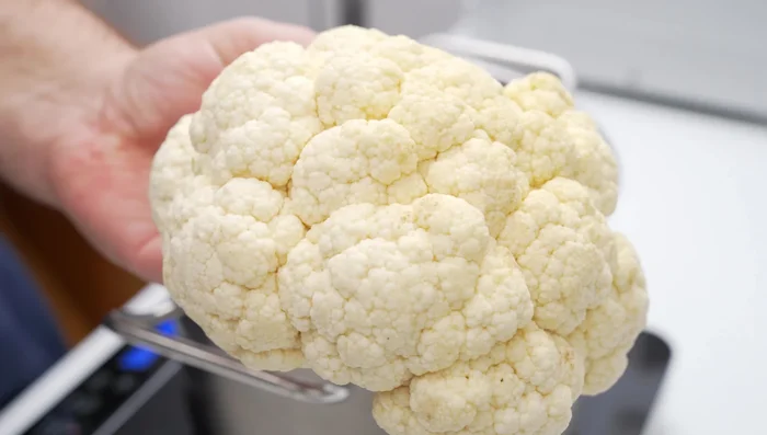 Parboil whole cauliflower (face down, weighted down) in boiling water for 10 minutes.