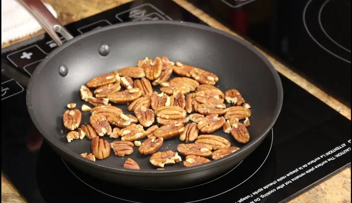 Toast pecans in a pan on medium-high heat for 1.5 minutes, until the color changes. Transfer to a plate to cool.