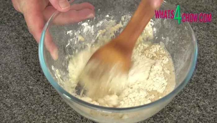 Add the frothy yeast mixture to the bowl. Stir with a wooden paddle until a dough forms.
