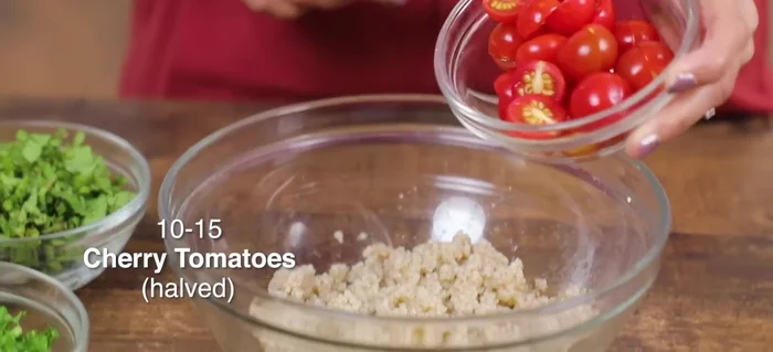 Add chopped cherry tomatoes (or regular tomatoes), finely chopped red onion (or spring onions), and chopped English cucumber to the millet mixture.